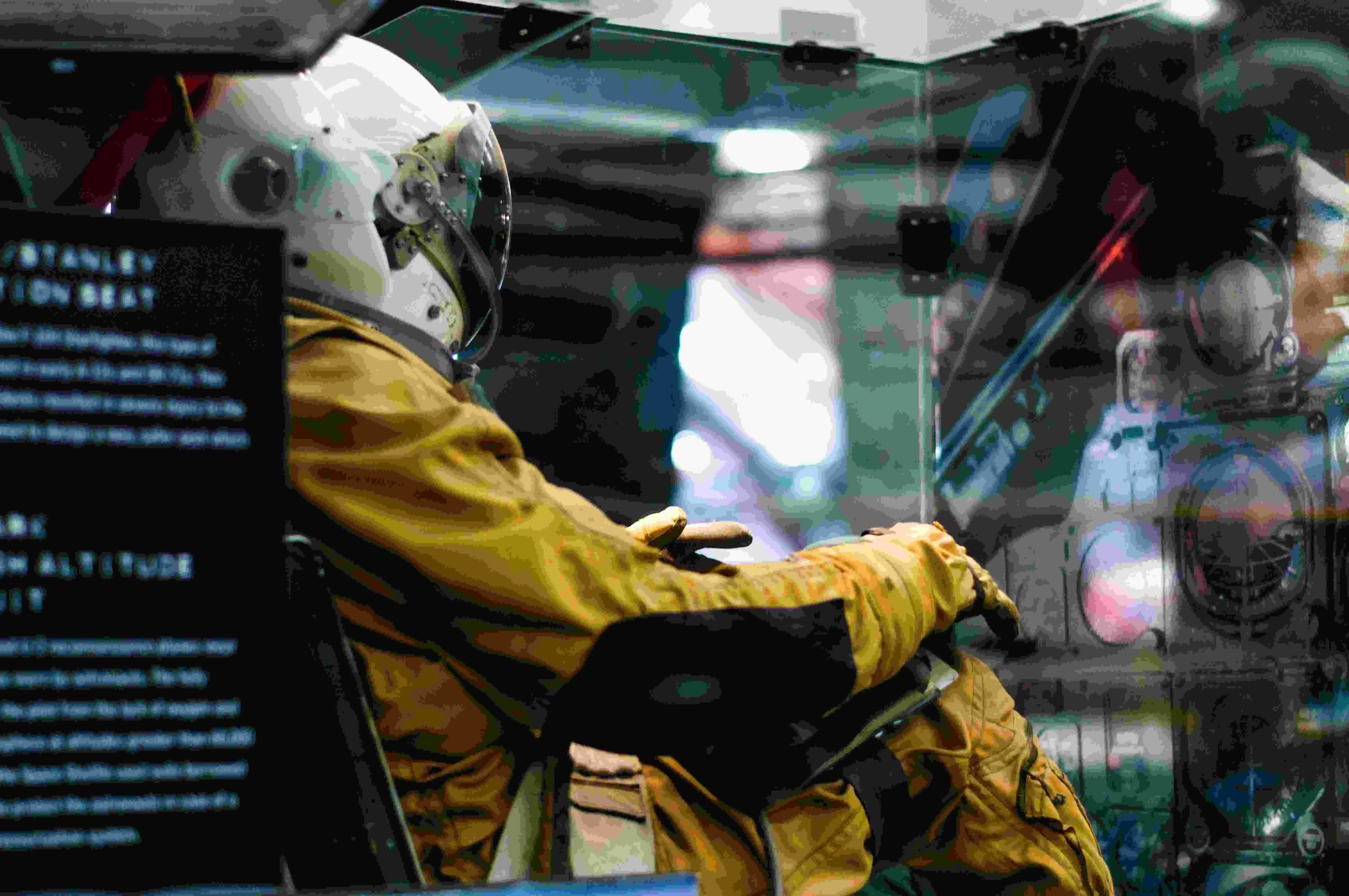 A Astronaut sitting inside a room with a picture of a spaceship