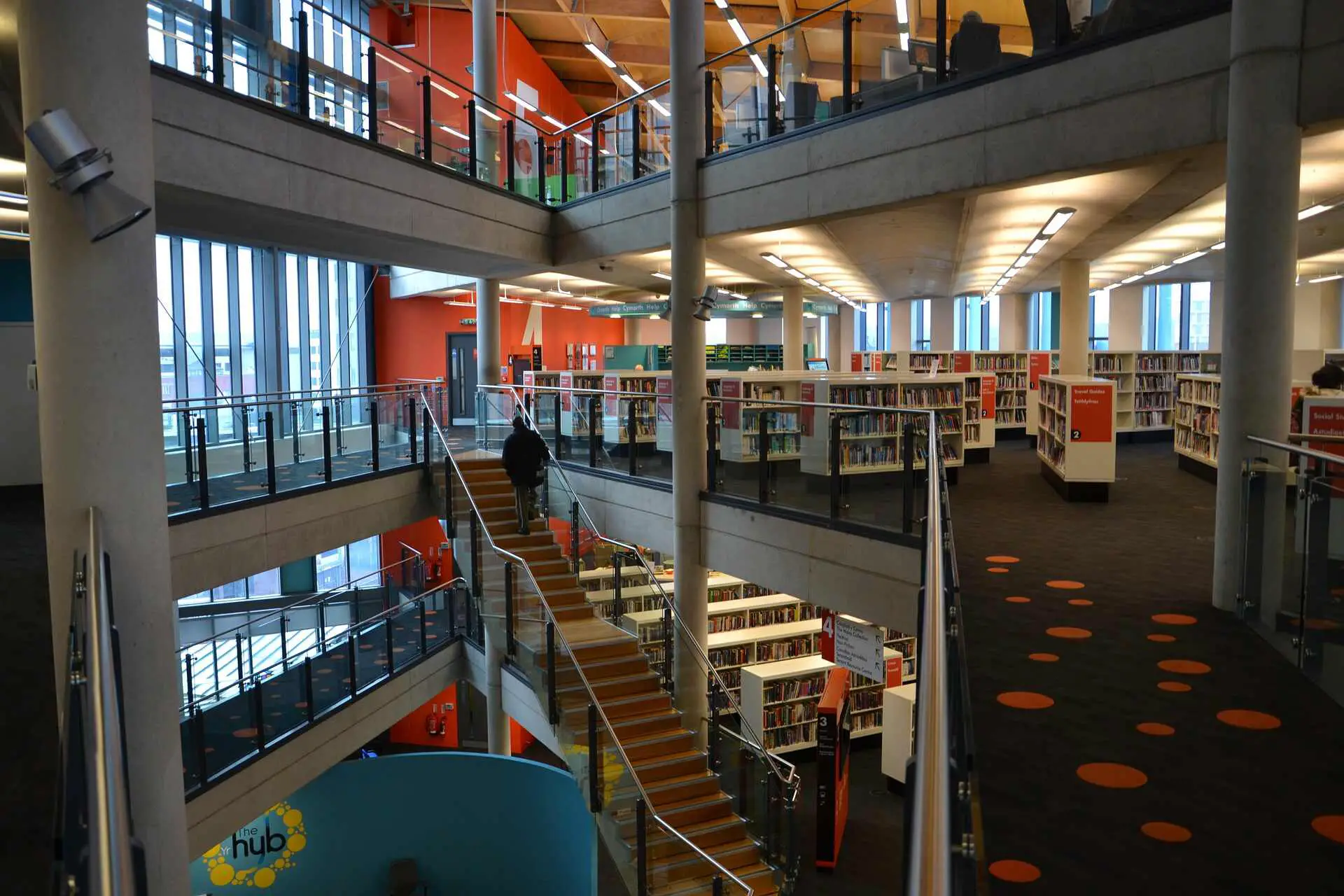 A picture of three stories tall open plan hallway with short book-shelves on each floor.
