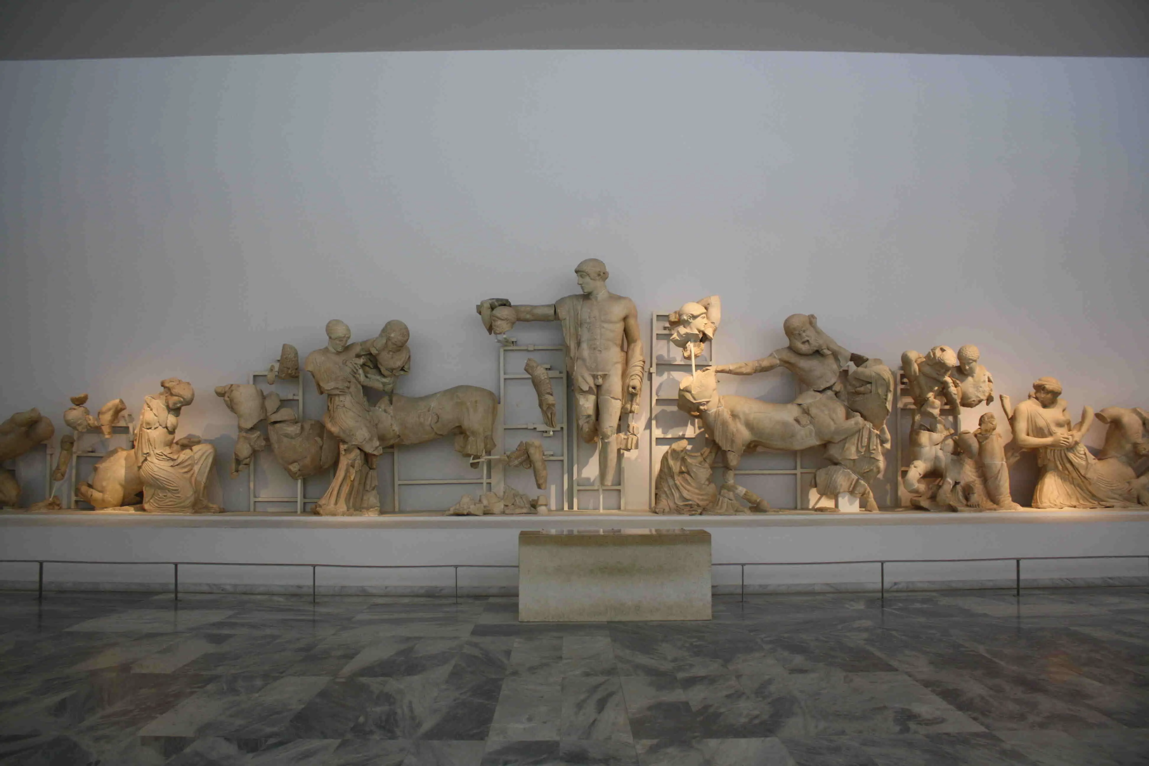 A photo of mostly broken stone statues lined up.