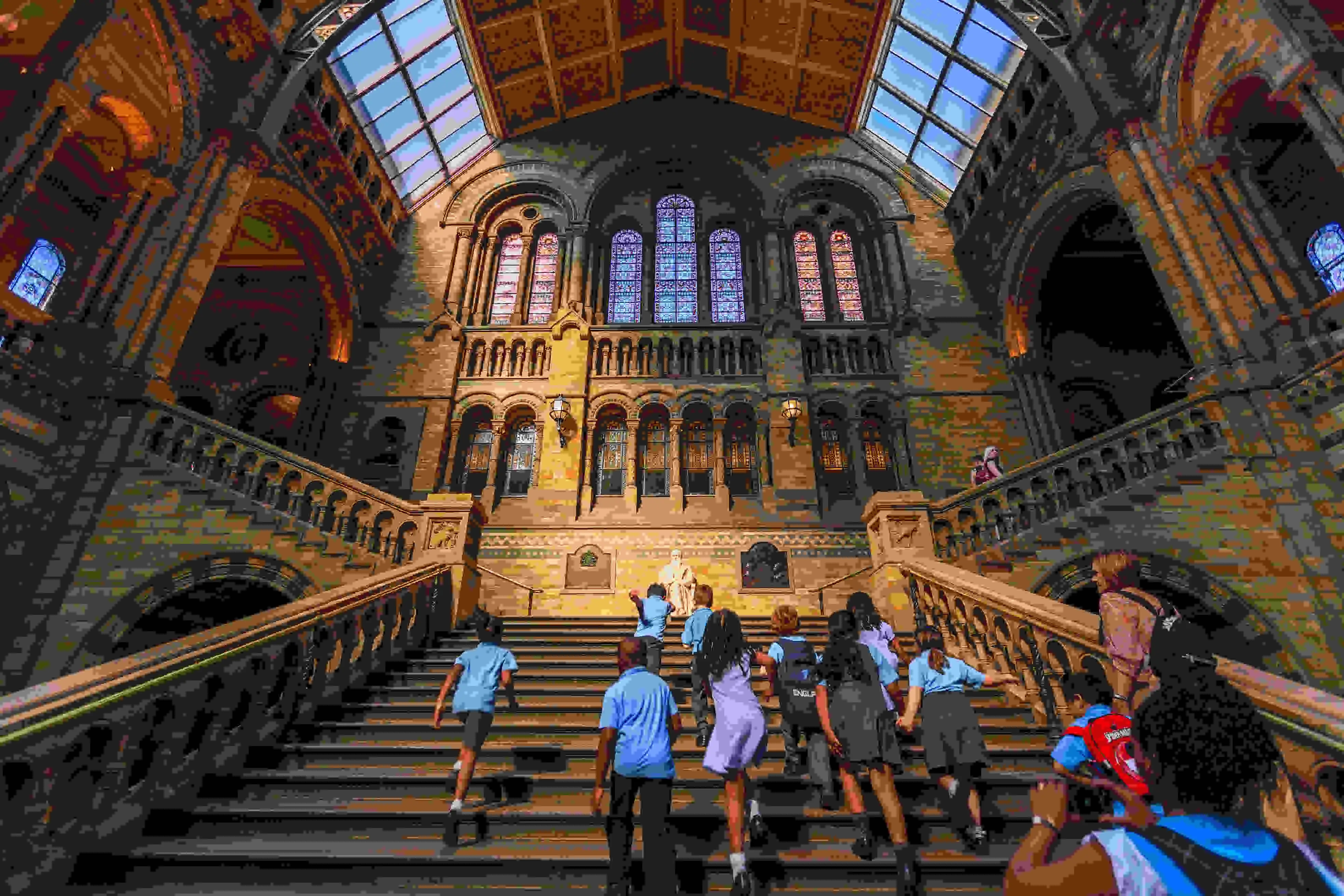 A picture of a stuffed elephant in the center of a tall rounded hallway.